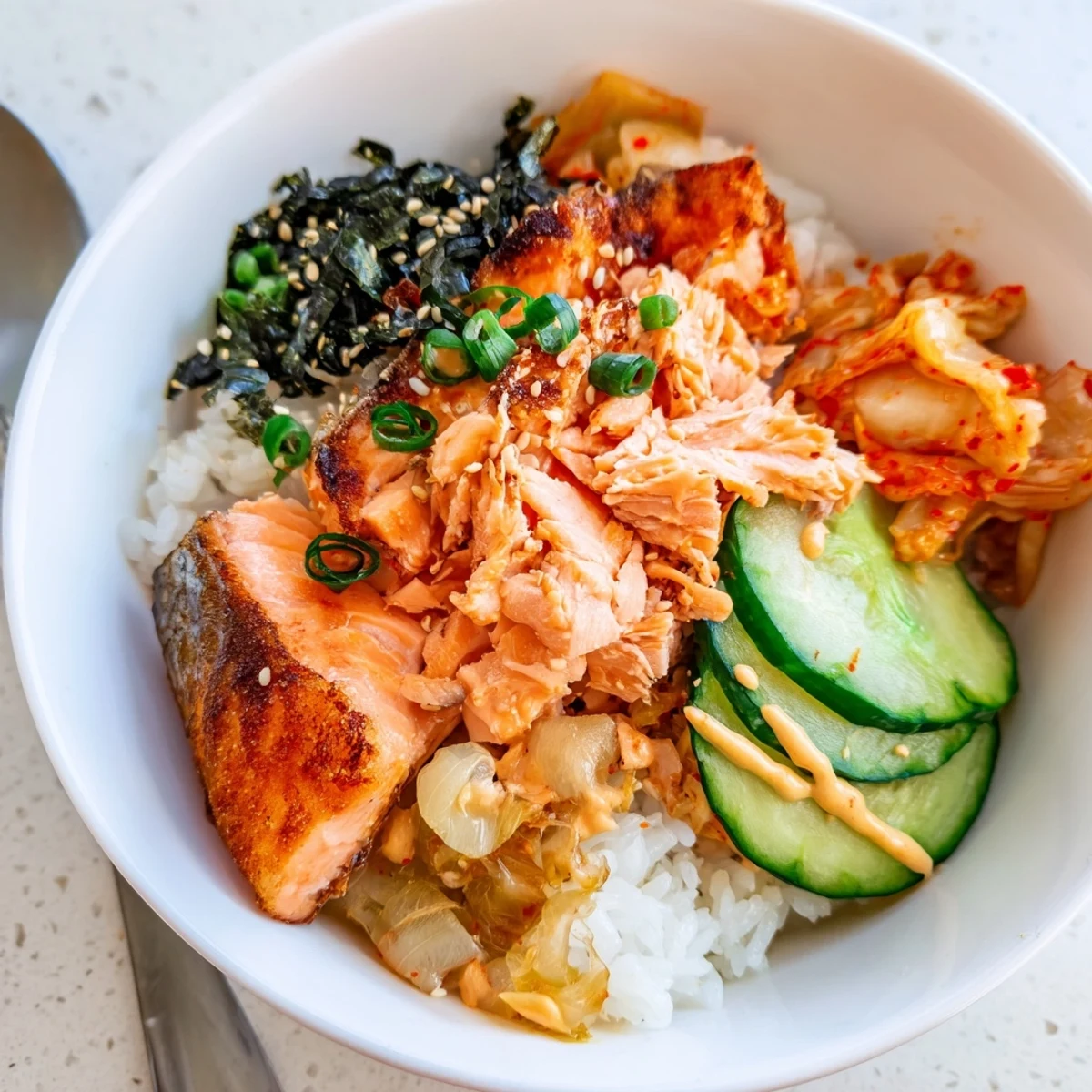 Crispy Salmon Rice Bowl with spicy mayo, avocado, and tangy kimchi toppings.  