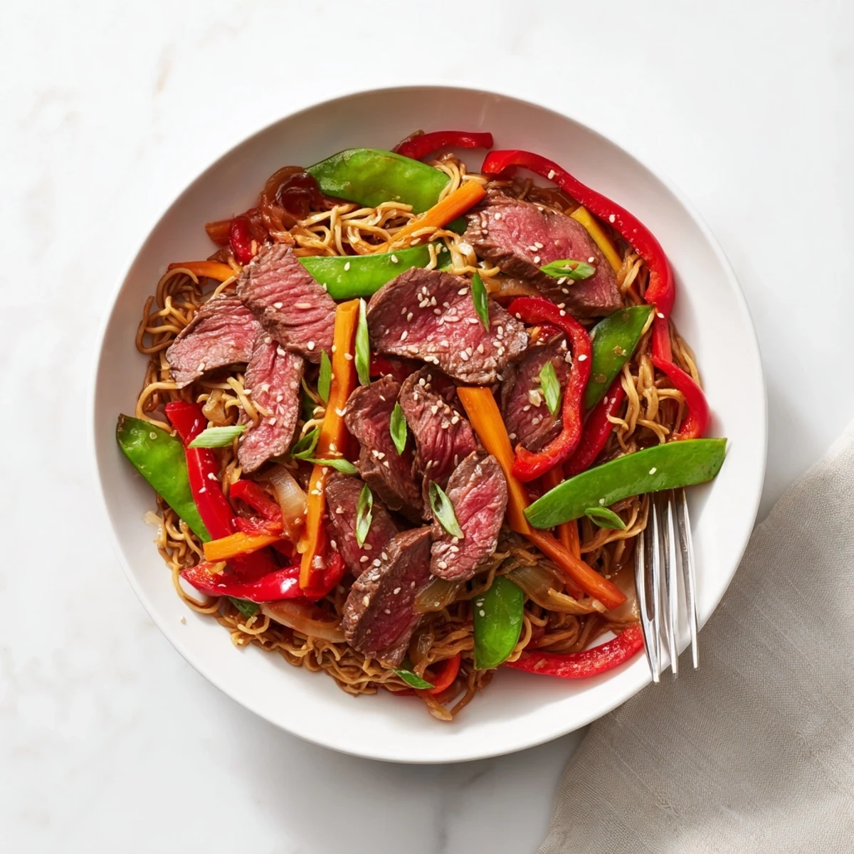 Steaming Teriyaki Beef & Noodle Bowl with colorful vegetables, coated in glossy teriyaki sauce, ready to eat.