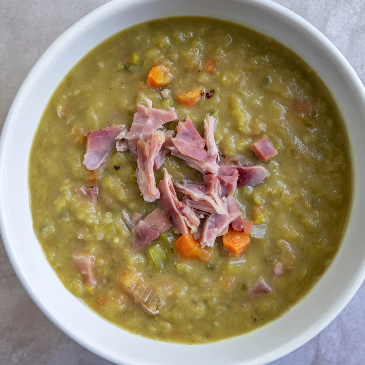 A steaming bowl of comforting split pea and ham soup, perfect for a chilly evening meal.