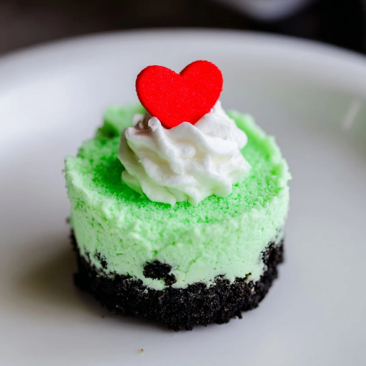 A close-up of vibrant green Grinch Mini Cheesecakes, ready to eat, showing texture and holiday spirit.