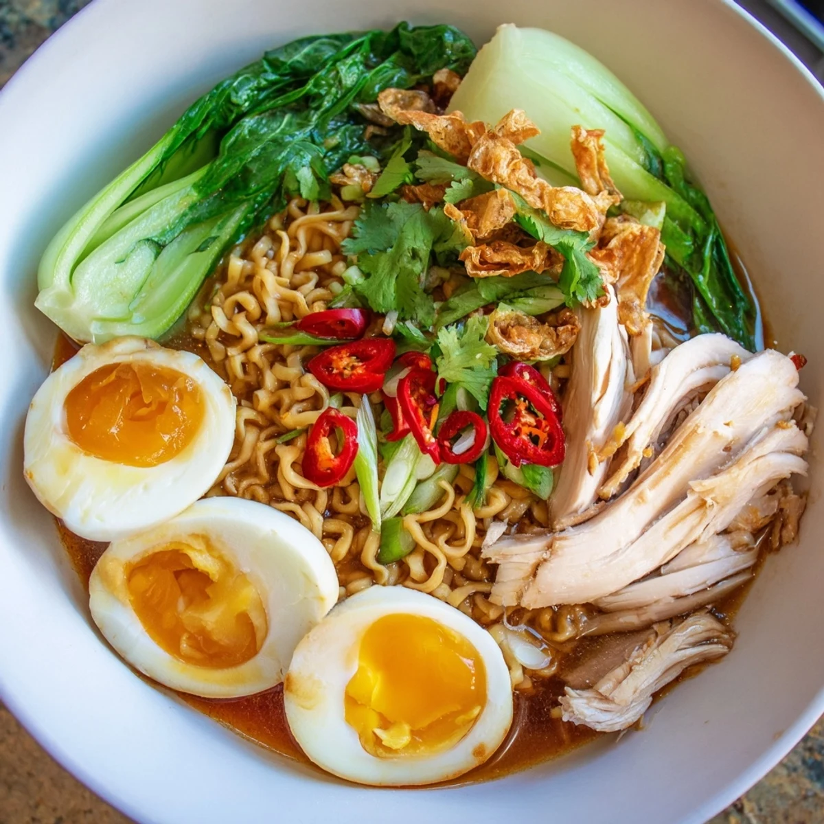 Steaming hot Thai Miso Ramen Bowl overflowing with tender chicken, bok choy, and soft-boiled eggs.