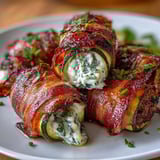 Savory zucchini halves stuffed with rich herbed cheese, wrapped in smoky bacon, and roasted to perfection for a keto-friendly dinner.  