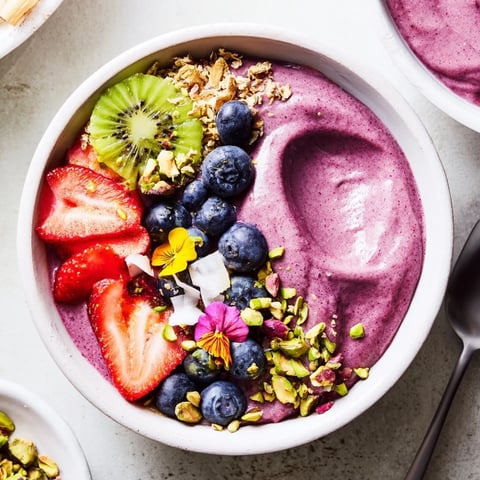 Colorful smoothie bowls topped with fresh fruits and nuts for a nutritious breakfast.  
