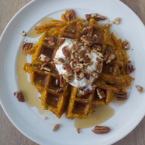 Golden, crispy sweet potato waffles, perfect for a cozy breakfast drizzled with maple syrup.