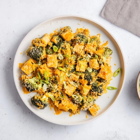 Golden-brown Cheesy Baked Tofu and Broccoli, smothered in sesame ginger sauce and sprinkled with green onions.