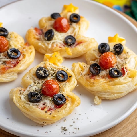 Golden, cheesy puff pastry Christmas Tree Pizza Bites boast vibrant tomato "ornaments" ready for a holiday feast.