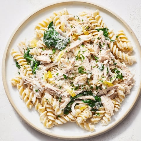 One-pot creamy spinach & turkey Christmas pasta steaming in a skillet, ready to serve with Parmesan.