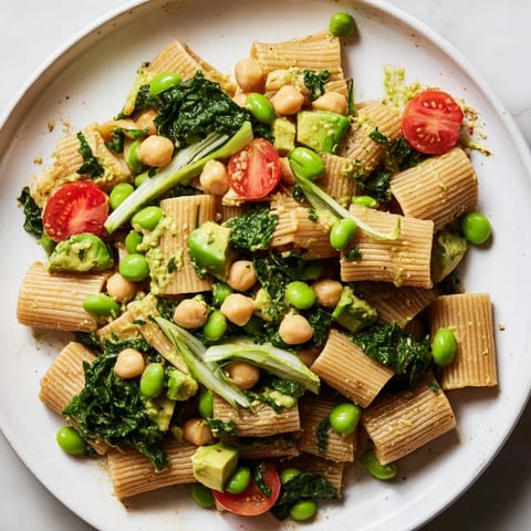 Holiday Glow Green Goddess Protein Pasta Salad, featuring tossed pasta and vibrant green vegetables, looks fresh.