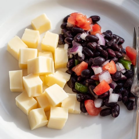 Pepper Jack cubes nestled near vibrant black bean salsa, perfect for a savory bite.