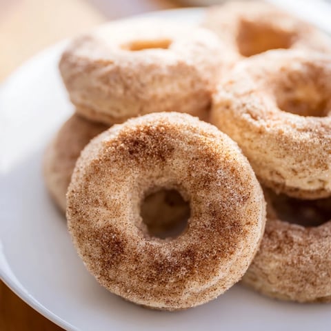 Golden, freshly baked cinnamon-sugar donuts ready for dipping, a classic American dessert.