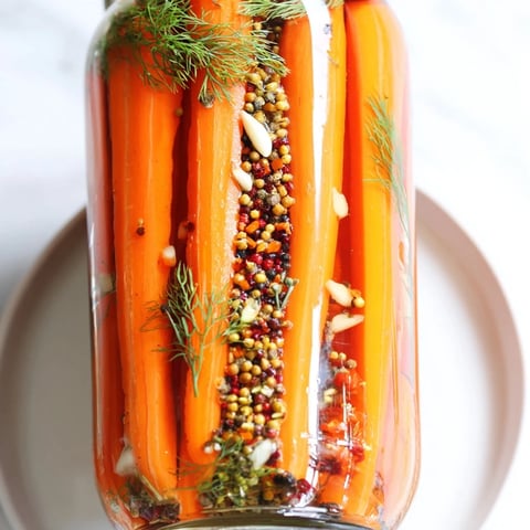 Quick Pickled Carrot Spears: Glistening, tangy carrots in a jar, ready for refrigerator pickles.