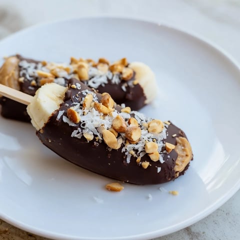 Frozen Banana Chocolate Pops: Peanut butter and chocolate-covered bananas, ready for a delicious, refreshing summer treat.