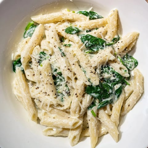 Steaming Creamy Spinach Pasta, presented with extra Parmesan, looks perfect for dinner tonight.