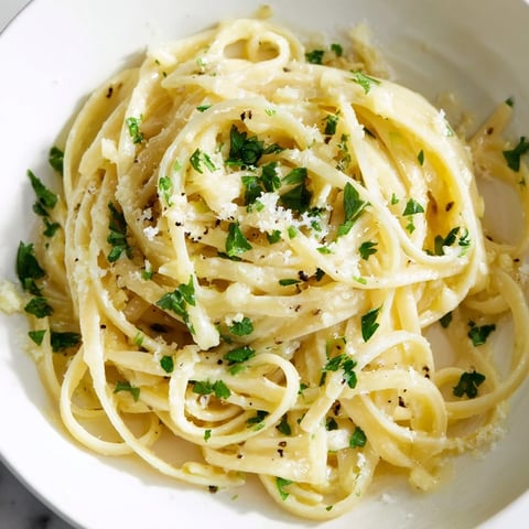 Golden garlic butter linguine, glistening with parsley, is a quick and comforting Italian dinner.