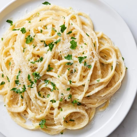 Creamy Pasta Alfredo Cottage Hack, made with smooth cheese sauce and fresh parsley garnish.