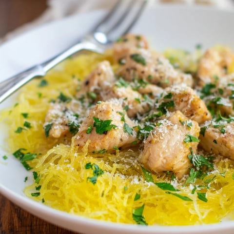 Golden roasted spaghetti squash strands topped with tender lemon-garlic chicken pieces, finished with a sprinkle of Parmesan and fresh parsley.