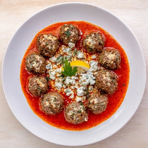 Steaming Instant Pot Greek-Style Meatballs with bright lemon-feta sauce, ready for your plate.