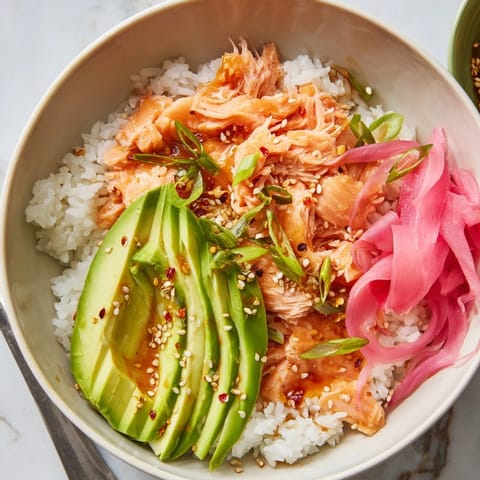 Flavorful salmon and rice bowl steaming in the microwave, topped with sesame seeds.  