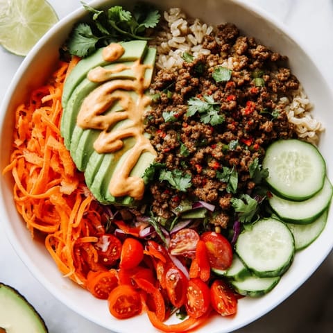 Colorful bowl of plant-based meat served with avocado and zesty lime wedges.  