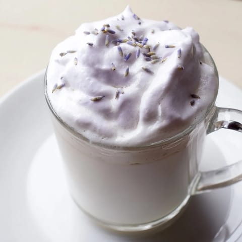 Steaming whipped lavender latte, featuring homemade lavender syrup and a cloud of lavender-infused foam.
