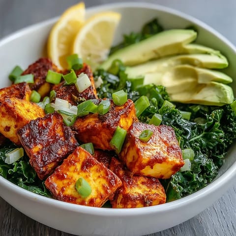 A nourishing Tofu Breakfast Bowl with Avocado and Kale, finished with lemon wedges on a rustic table.