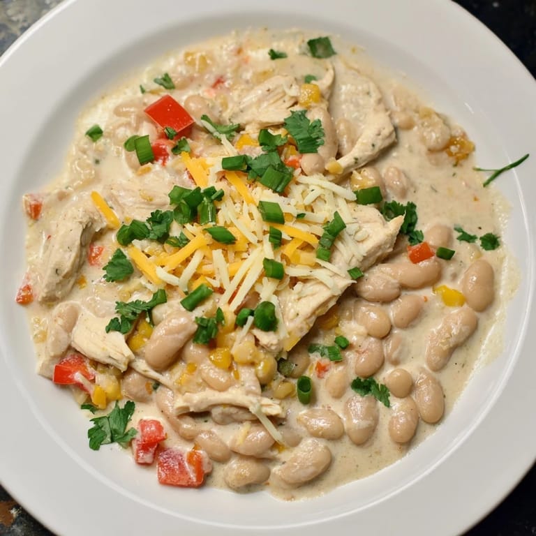 A large pot of bubbling Creamy White Chicken Chili with beans, ready to spoon into warm bowls.
