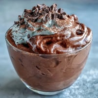 Silky high-protein cottage cheese chocolate mousse topped with fresh berries and shaved dark chocolate for a decadent yet healthy treat.  