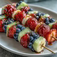 Festive Fourth of July red, white, and blue fruit skewers with strawberries, bananas, and blueberries for patriotic celebrations.